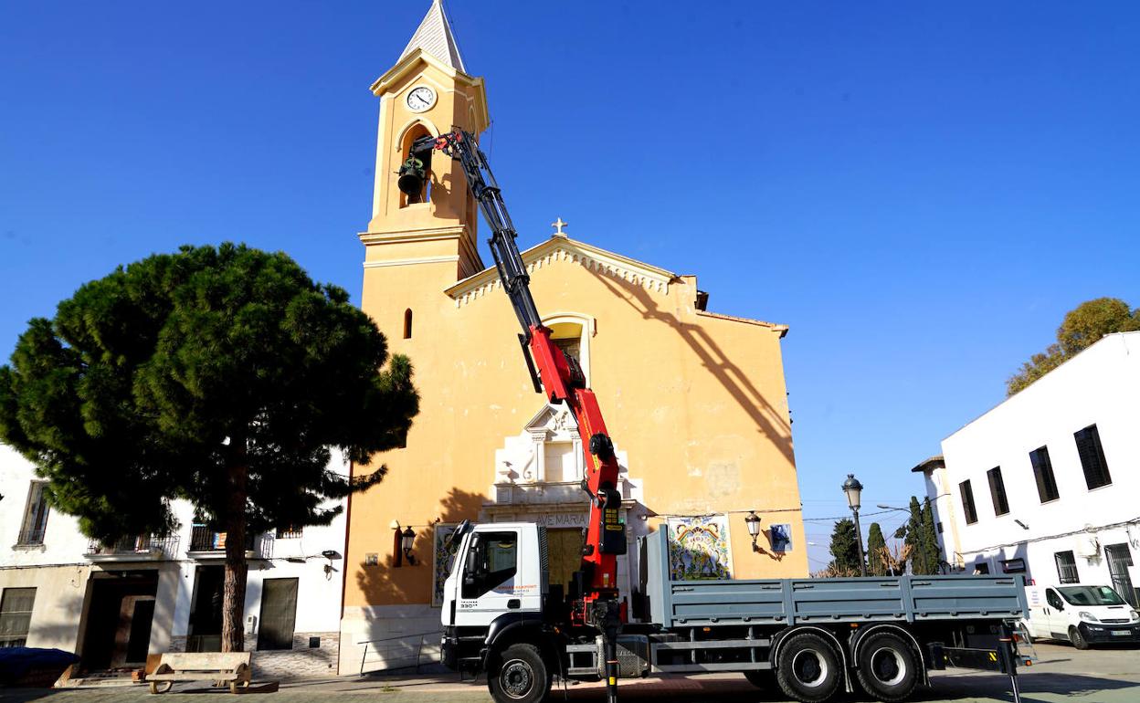 La grúa baja una de las campanas. 