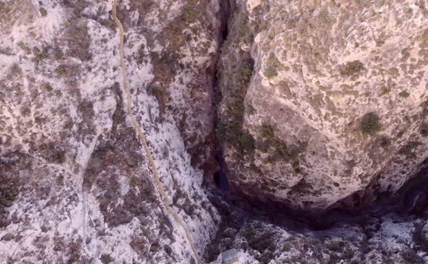 Imagen del pantano resguardado sobre las verticales montañas. 