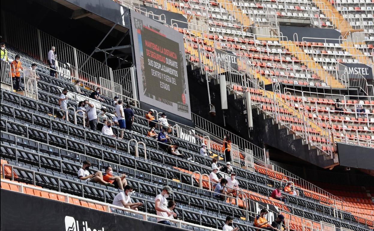 Público con distancia de seguridad y mascarilla en Mestalla.