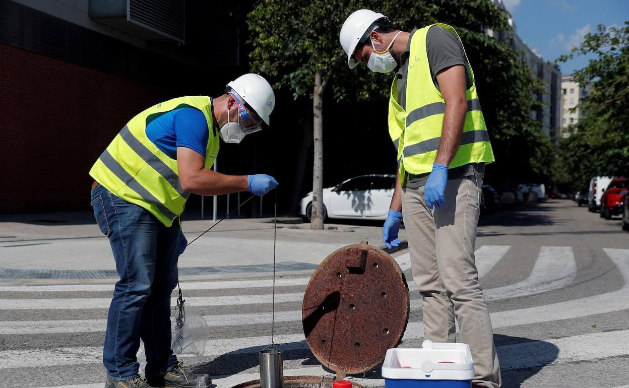 Dos técnicos comprueban el estado de las aguas residuales. 