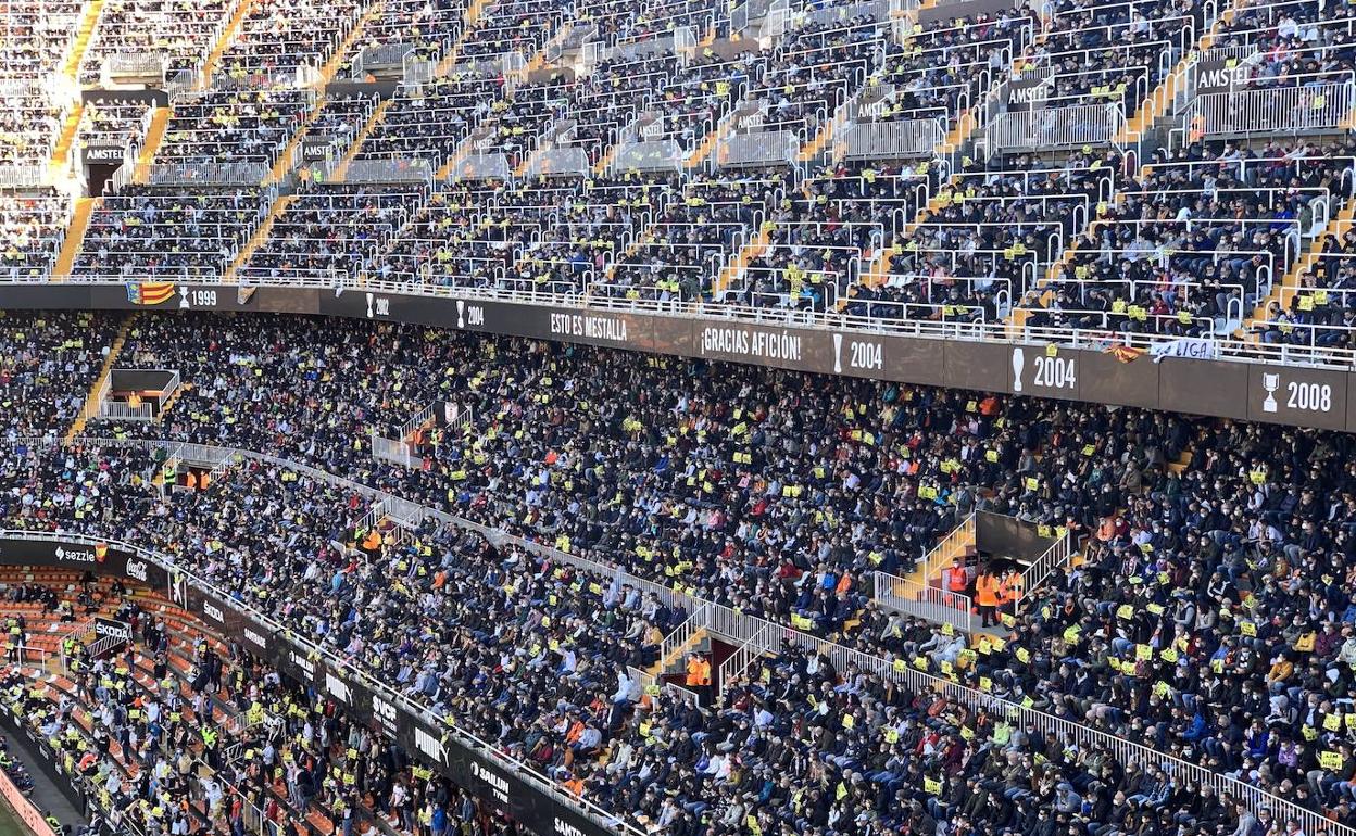 El fondo sur de Mestalla, muestra carteles amarillos que rezan 'Lim go home'. 