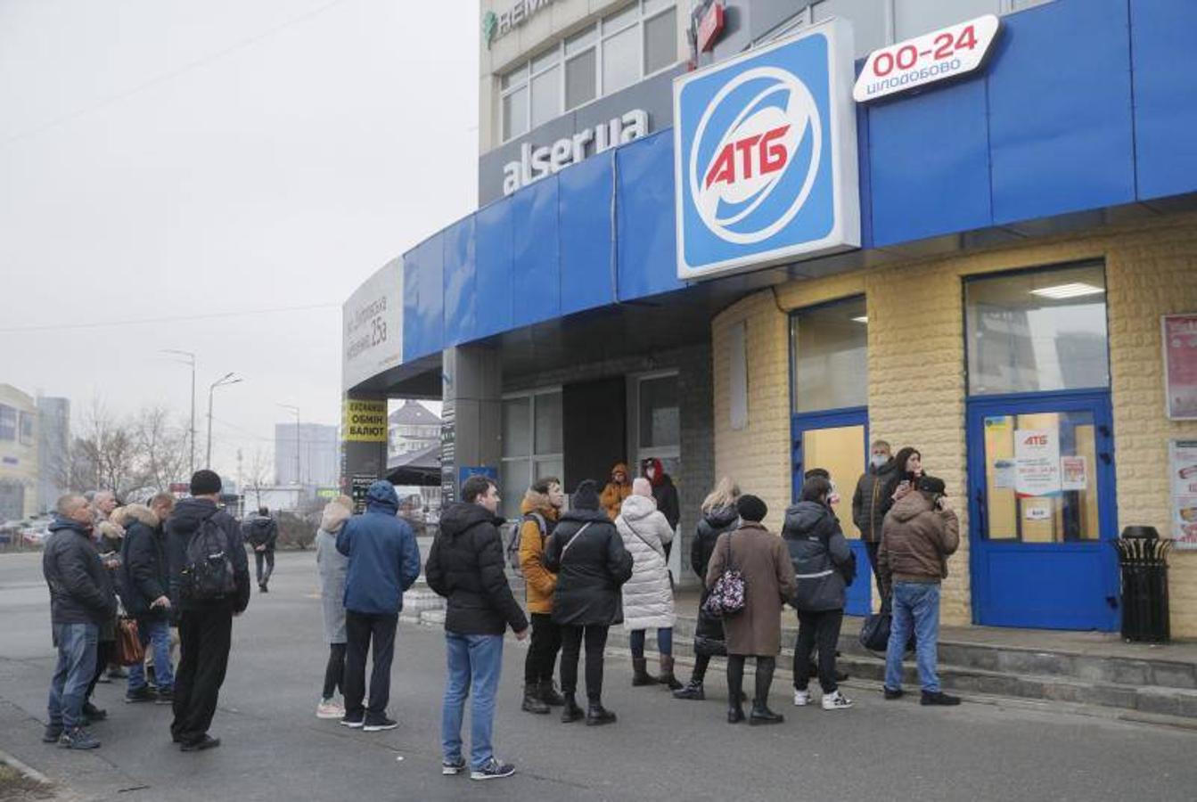 La gente hace cola frente a una tienda de comestibles en Kiev, Ucrania.