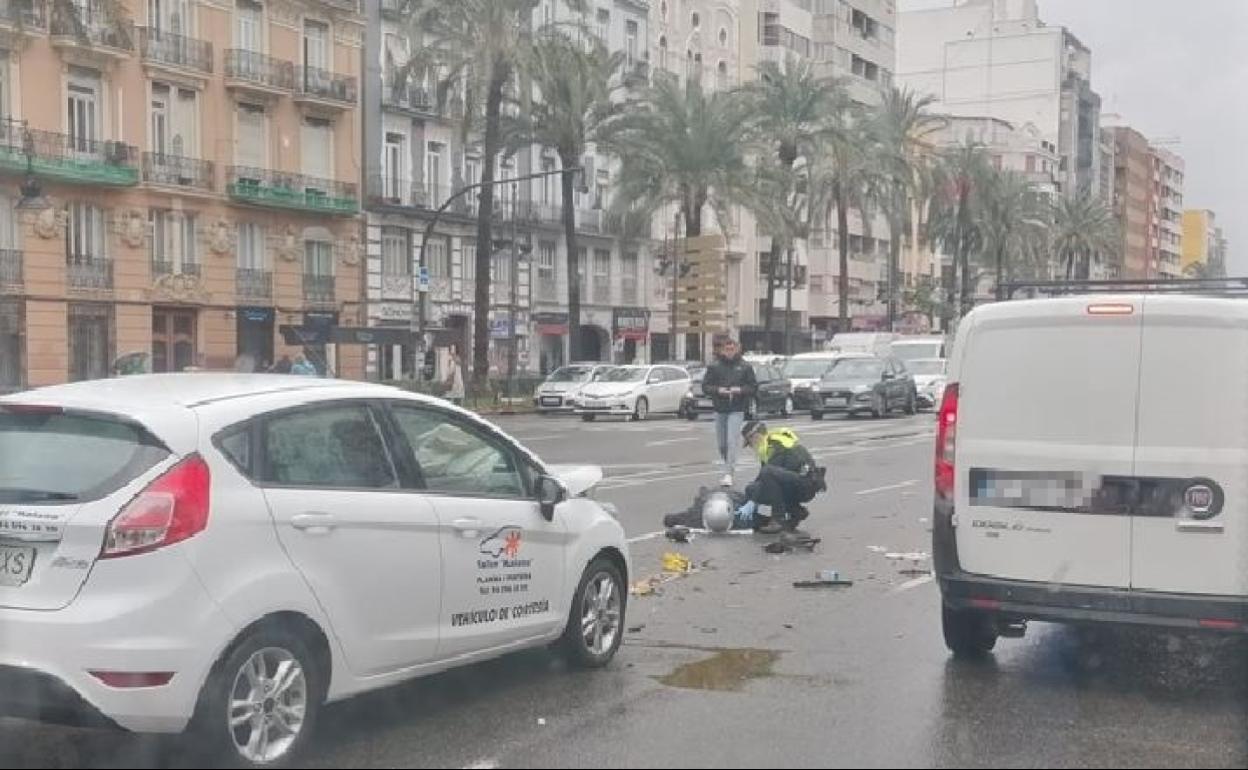 Un policía local auxilia al motorista herido. 