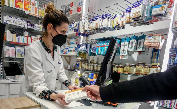 Una farmacéutica despacha a un cliente en la ciudad de Madrid. 