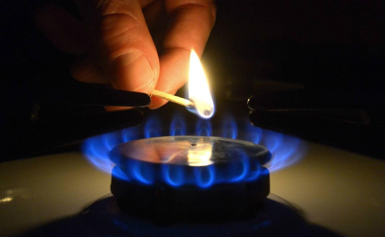 Un hombre enciende un quemador de una cocina de gas