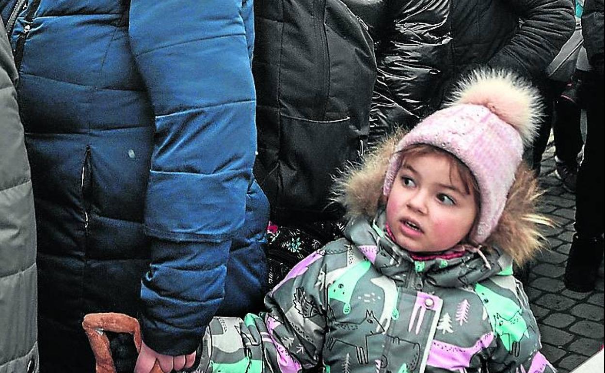 Una niña espera en una fila de refugiados tras cruzar a Polonia.