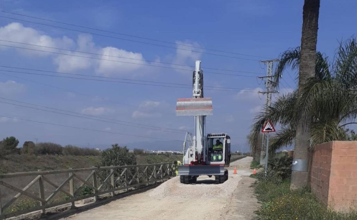 Una máquina trabajando en el camino del Barranco del Carraixet. 