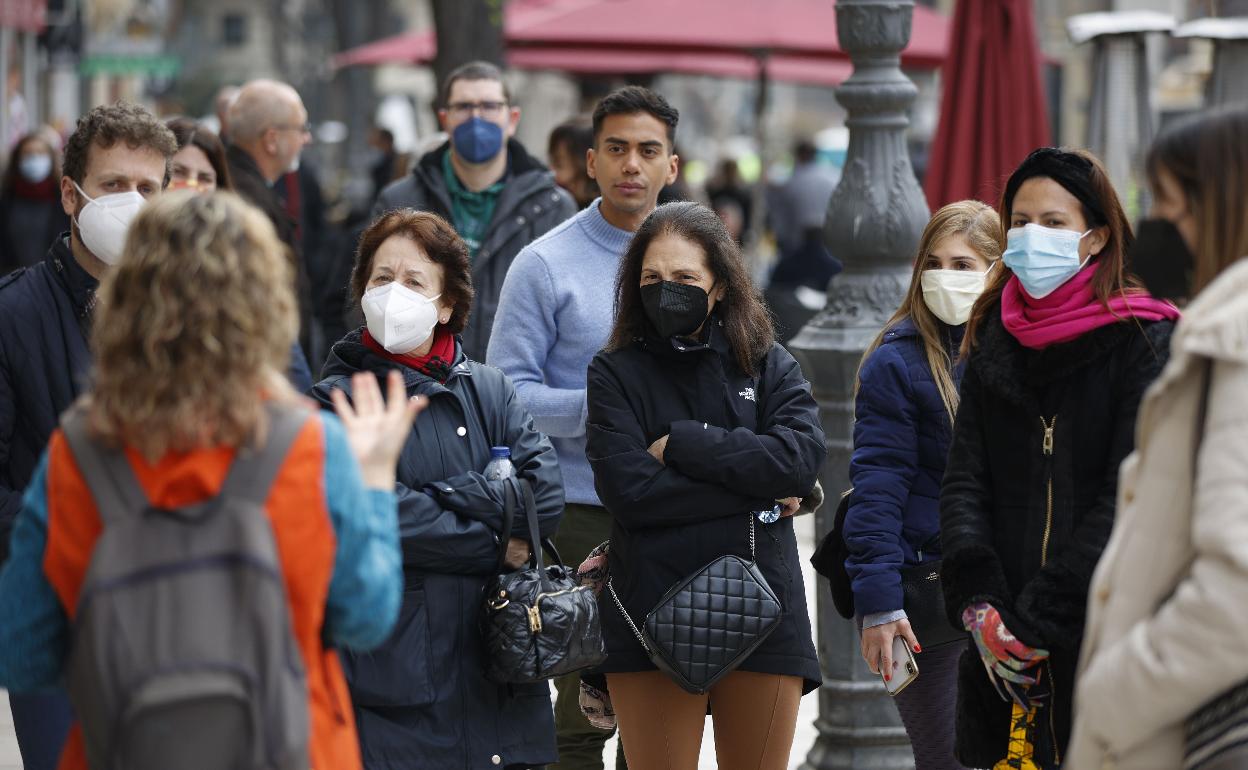 Varios ciudadanos con mascarilla por las calles de Valencia. 