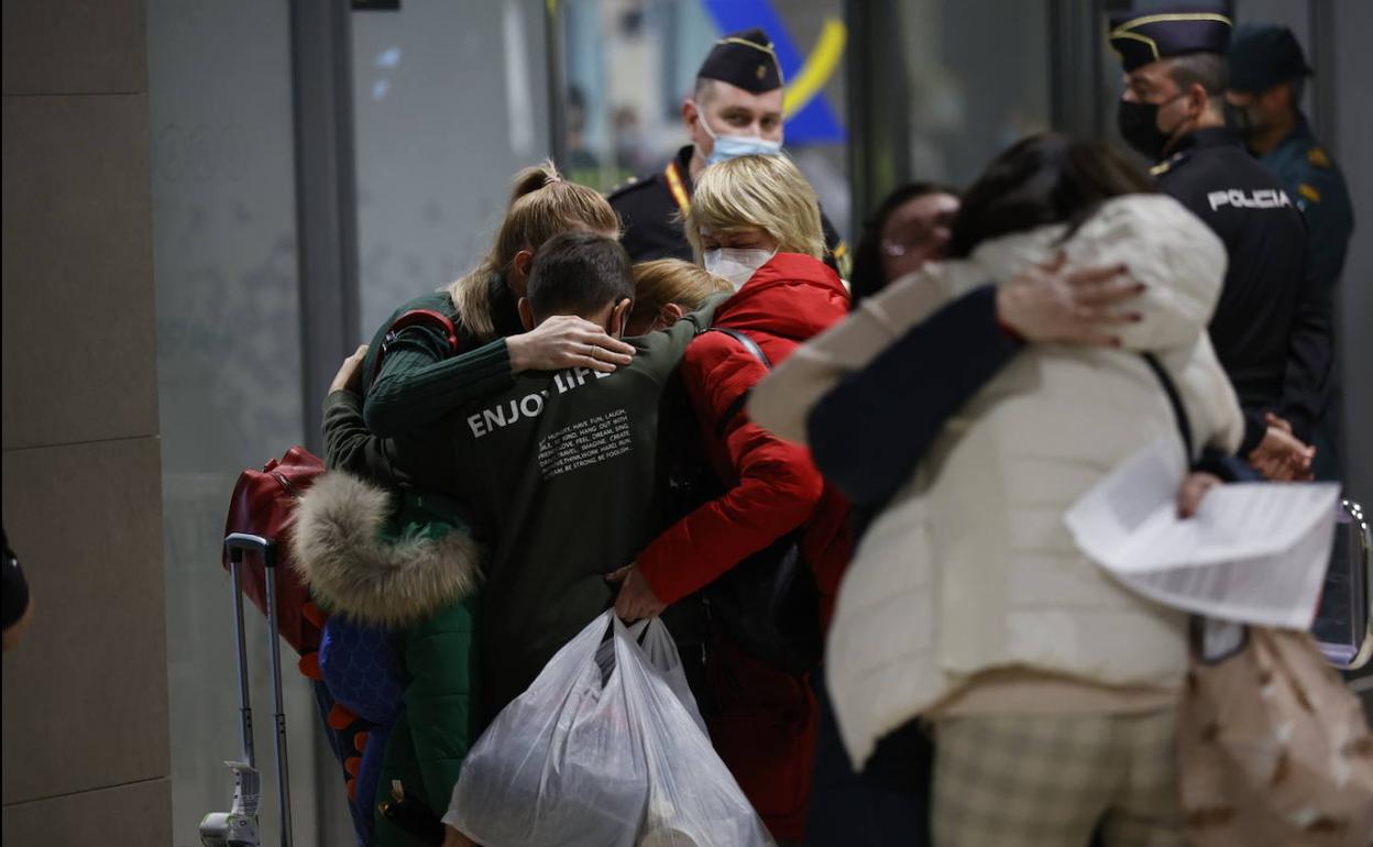 Una familia se abraza tras su llegada al aeropuerto de Manises.