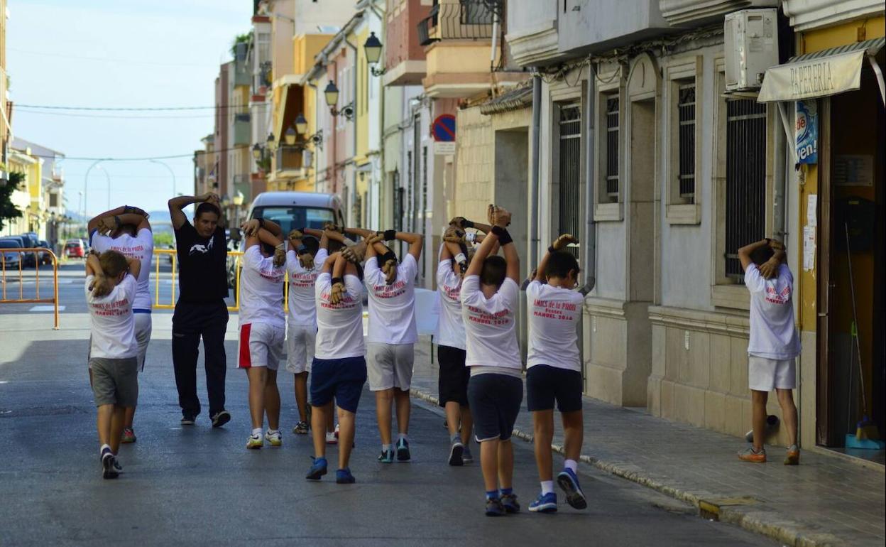 Julio Cabanes realiza estiramientos con los chavales de la escuela durante una competición. 