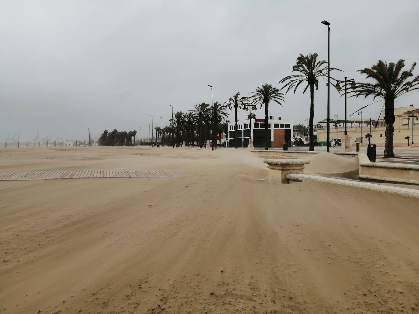 El paseo marítimo se ha llenado de arena por el temporal de viento en Valencia este 15 demarzo. 