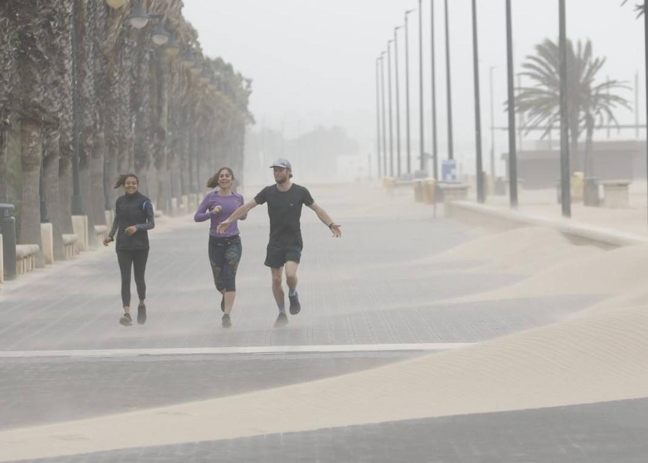 El paseo marítimo se ha llenado de arena por el temporal de viento en Valencia este 15 demarzo. 