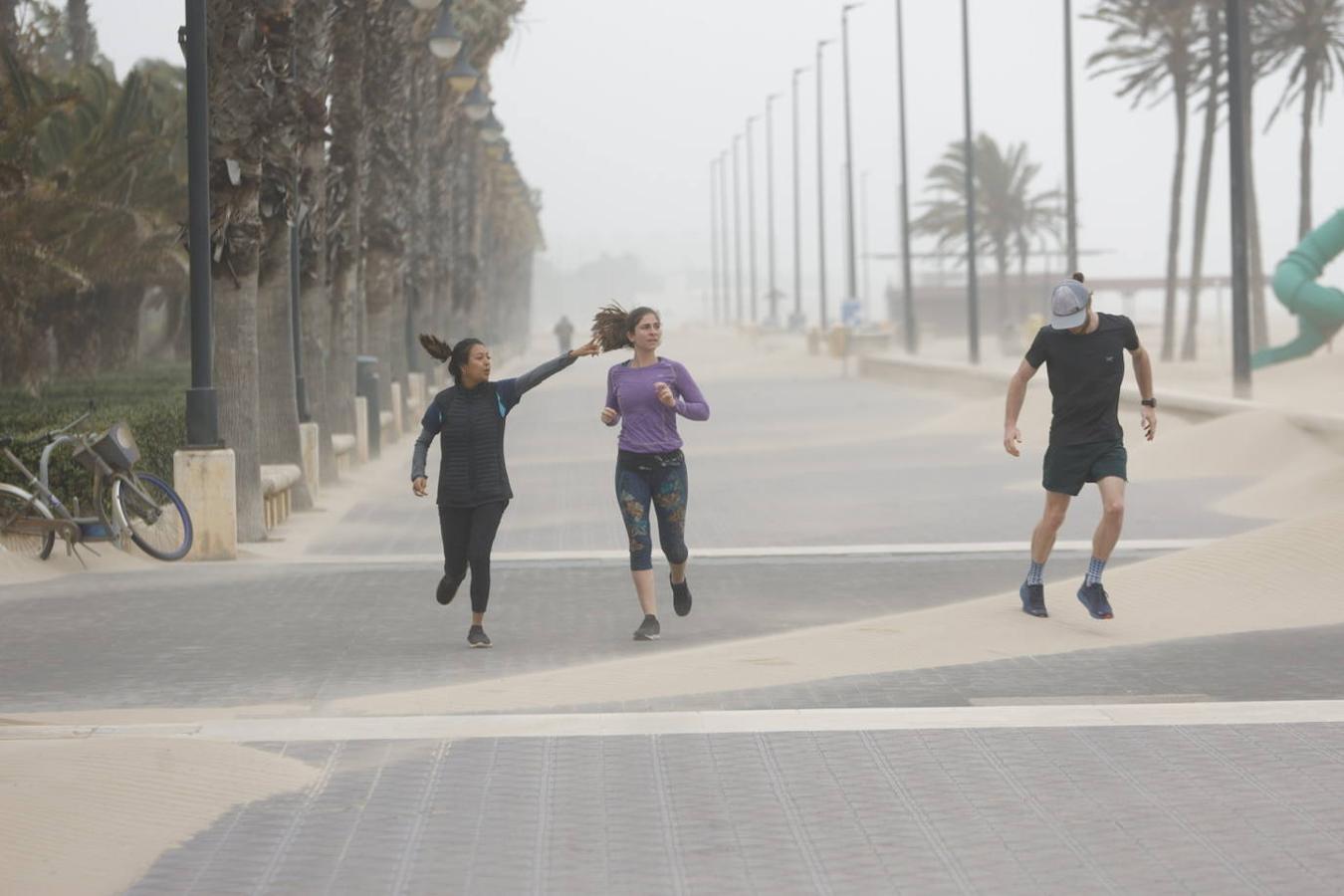 El paseo marítimo se ha llenado de arena por el temporal de viento en Valencia este 15 demarzo. 