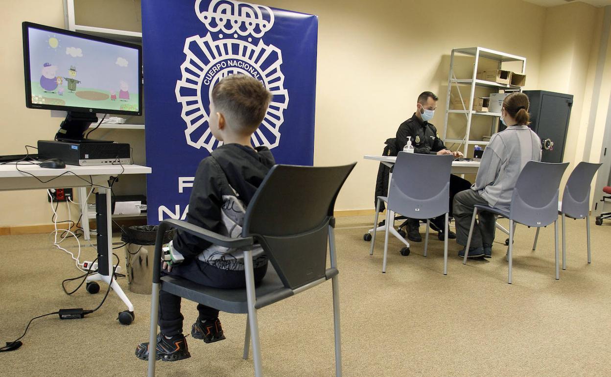 Un niño ucraniano ve dibujos de Pepa Pig mientras su madre tramita con un agente la documentación. 