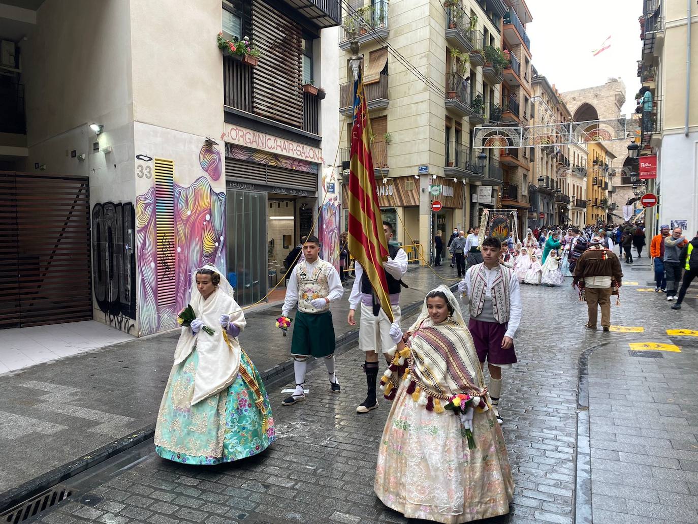 La lluvia no ha podido con el fervor a la Virgen de los Desemperados. La primera jornada de la ofrenda de las Fallas está pasada por agua y protagonizada por las flores y los paraguas, pero nada detiene la ilusión de los falleros de desfilar hasta la Mare de Déu. 