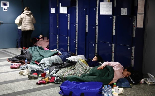 Un grupo de refugiados descansa en la estación de Cracovia