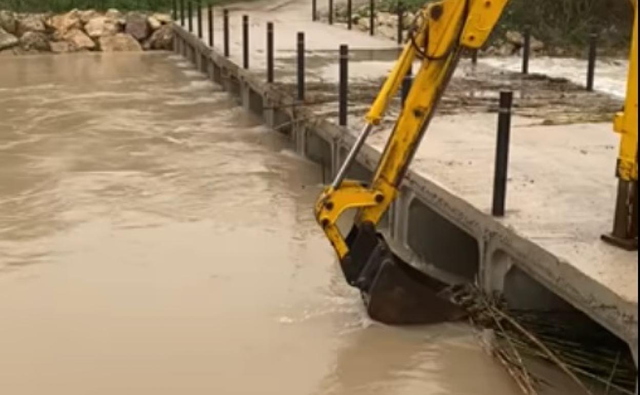 Cañas y ramas obstaculizaron el paso del río Canyoles por el puente que fueron retiradas. 