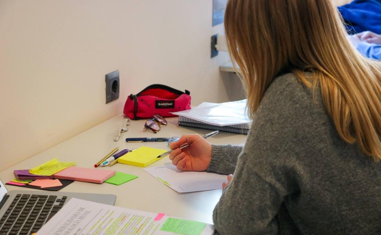 Una estudiante en una biblioteca. 