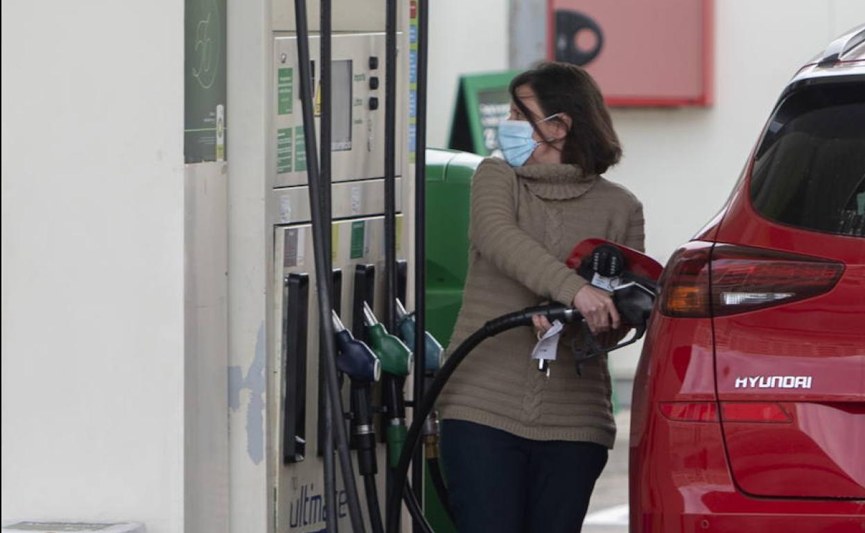 Una conductora reposta en una gasolinera.