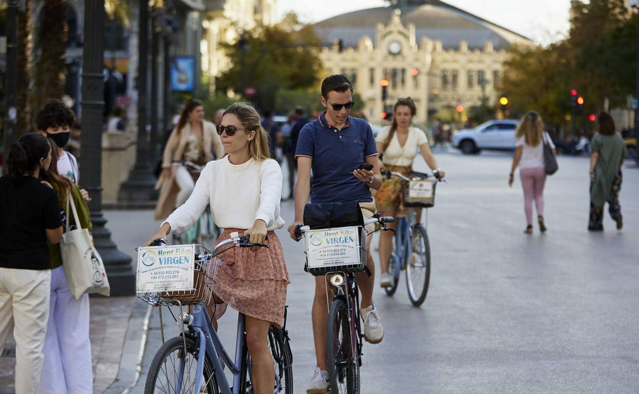 Turistas en bicicleta en el centro de Valencia. 