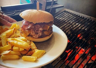 Imagen secundaria 1 - Una parrillada de carne y una de las hamburguesas cocinada a la brasa. 