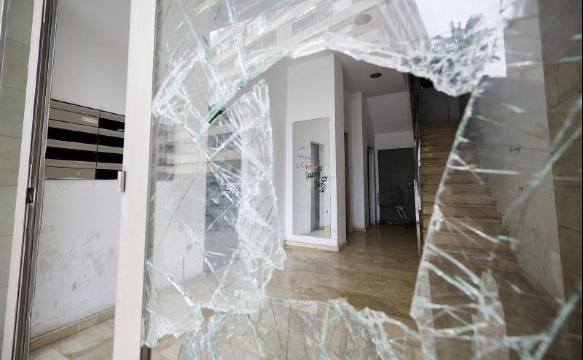 Patio con los critales rotos y la puerta forzada de uno de los edificios ocupados ilegalmente en Orriols. 