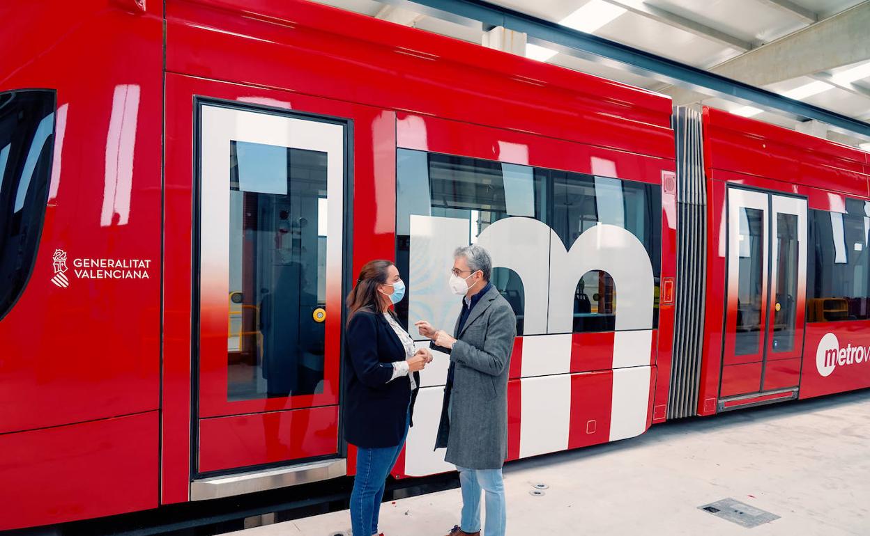 La directora de Ferrocarrils, Anaïs Menguzzato, y el conseller de Transportes, Arcadi España, junto a una de las unnidades con los nuevos colores. 