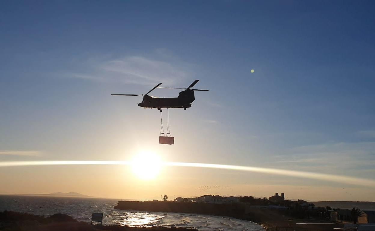 Un helicóptero transporta uno de los generadores a la isla de Tabarca. 