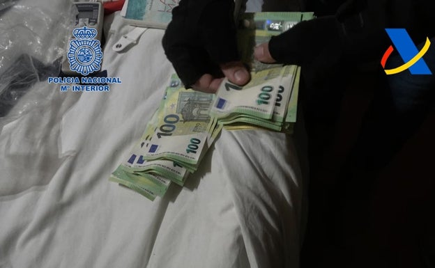 Uno de los policías cuenta los billetes de 100 euros intervenidos en uno de los registros. 