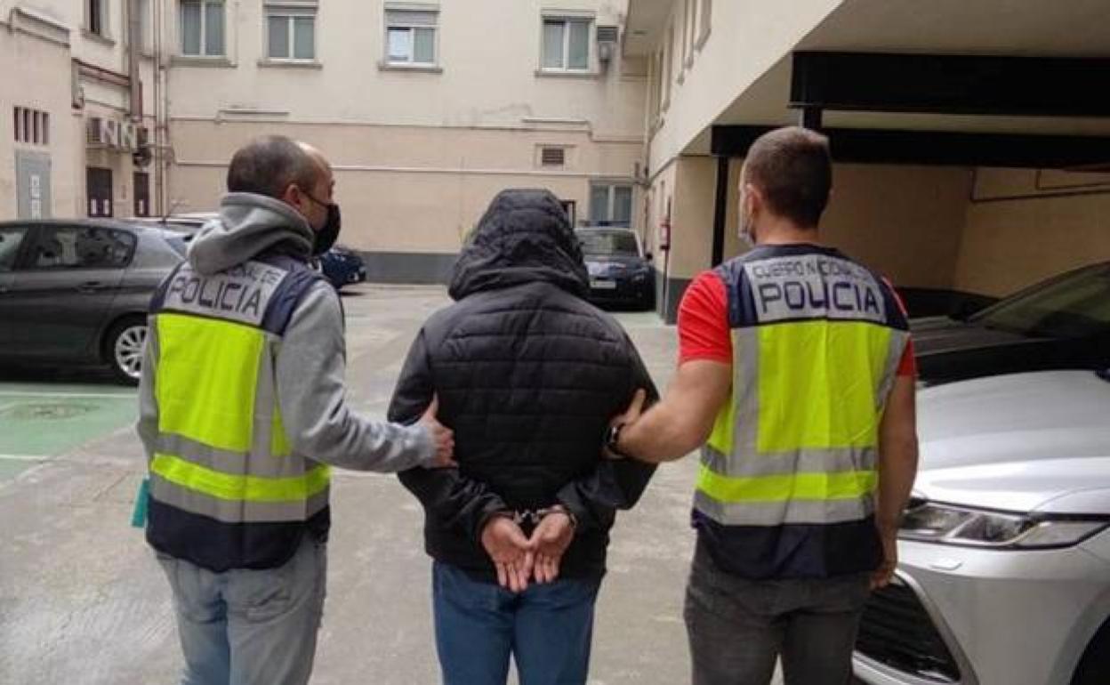 Dos agentes acompañan al fugitivo detenido en Bilbao. 