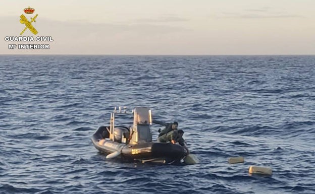 Los agentes recogen del mar los fardos de hachís. 