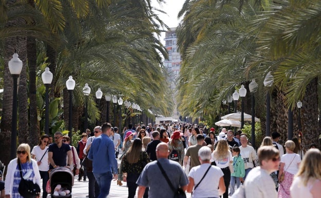 Miles de turistas y alicantinos pasean por la Explanada de España. 