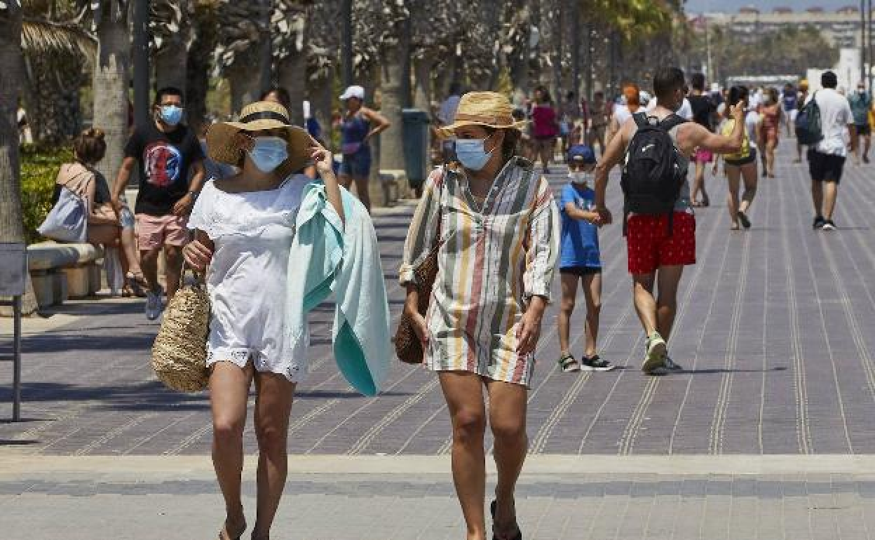 Turistas por el paseo de la playa de las Arenas de Valencia. / 