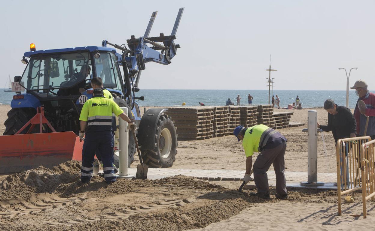 Operarios en los trabajos de colocación de las pasarelas este lunes. 