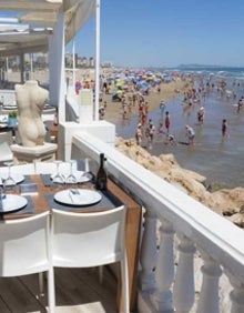 Imagen secundaria 2 - Arriba José Matías muestra su fideuà en el l restaurante Parsifal, en primera línea de la playa de Gandia. Abajo detalle de una fideuà del Restaurante Ripoll y vistas del local de toda la playa de Gandia. 