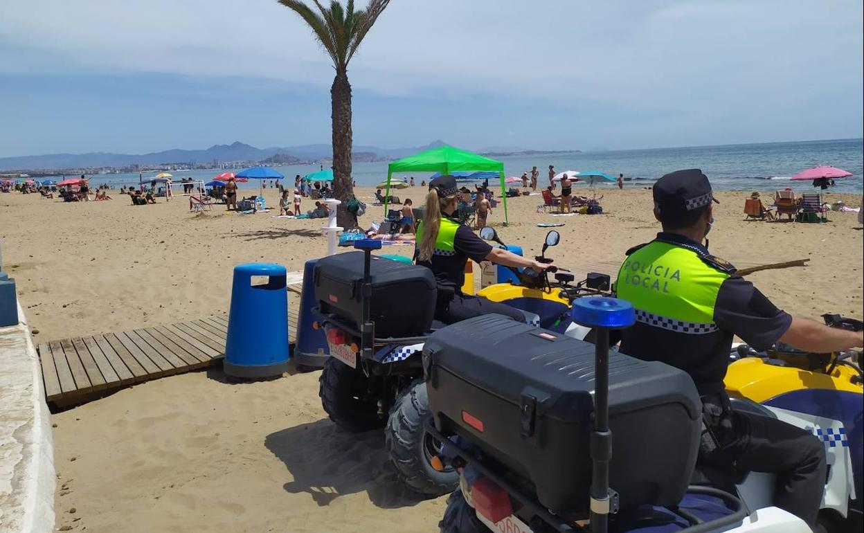 Un par de agentes vigilan en quad la playa de Urbanova. 