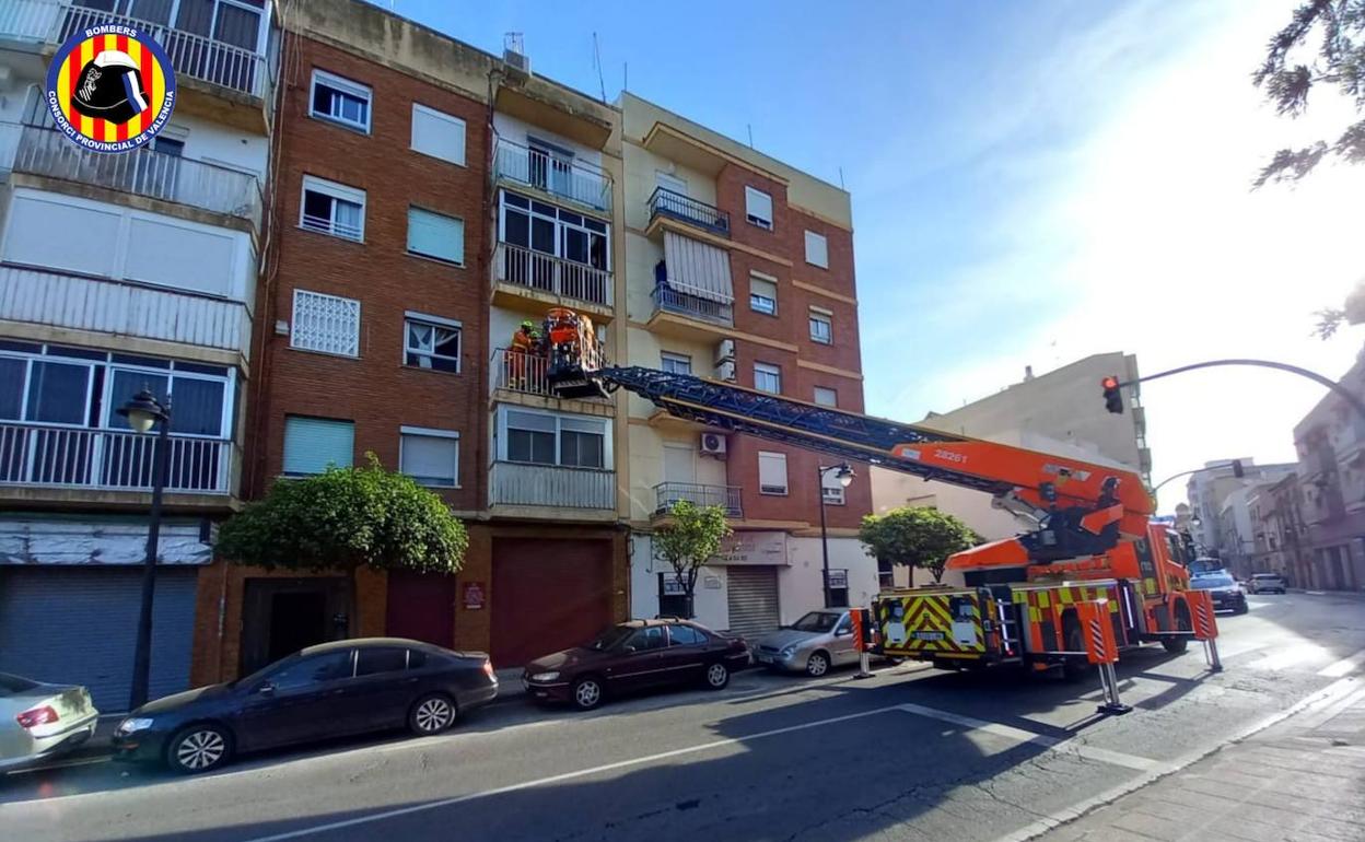 Los bomberos bajan al anciano con un vehículo de altura. 