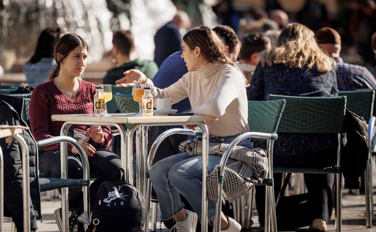 Personas consumiendo en una terraza de Valencia. 