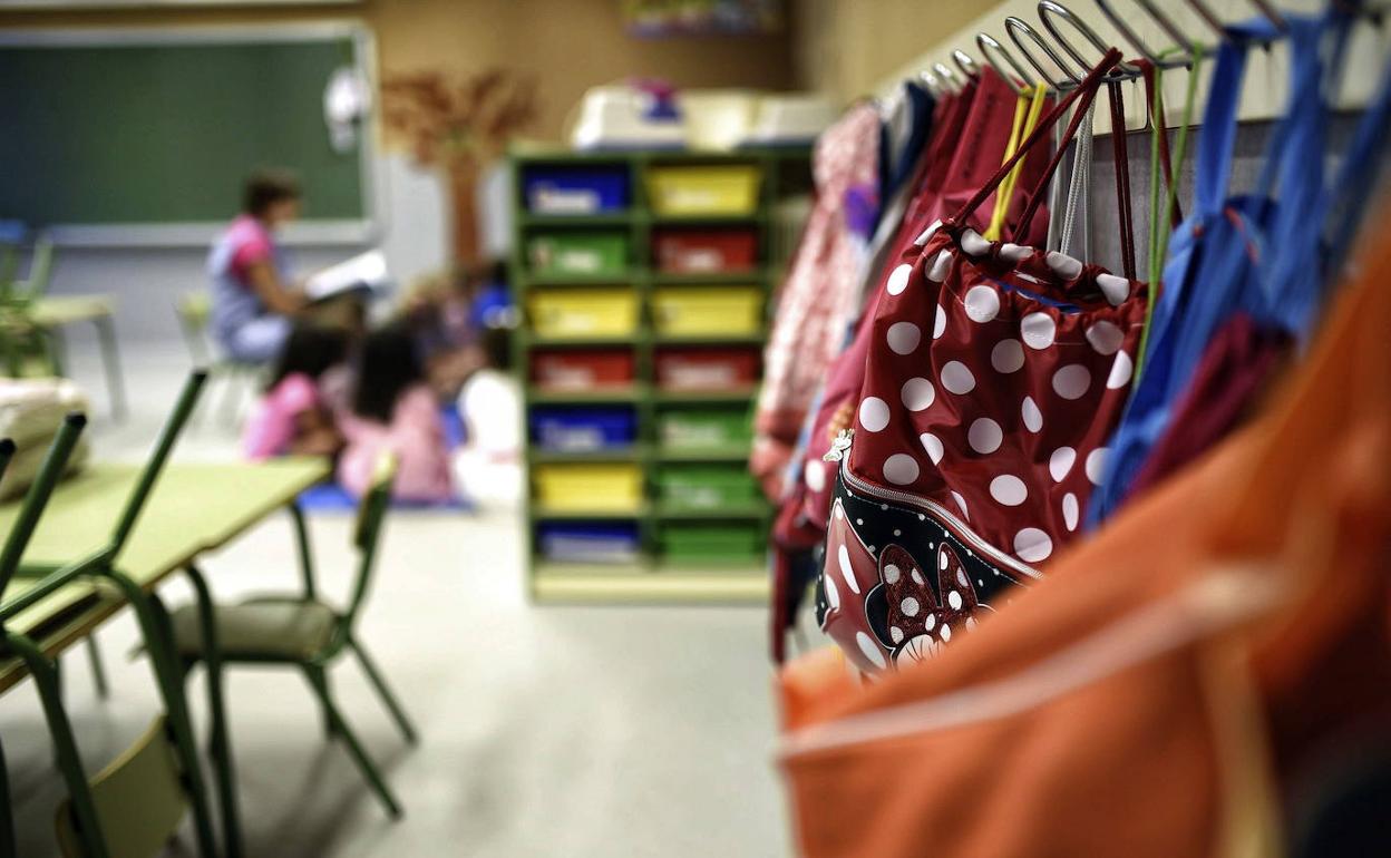 Mochilas colgadas en una clase de un colegio. 