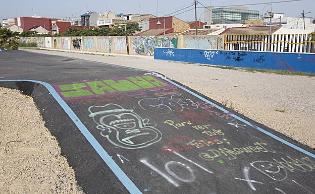 Imagen principal - Pista de 'pumptrack' llena de grafitis y rocódromo en la entrada del parque con faltantes y maleza. 