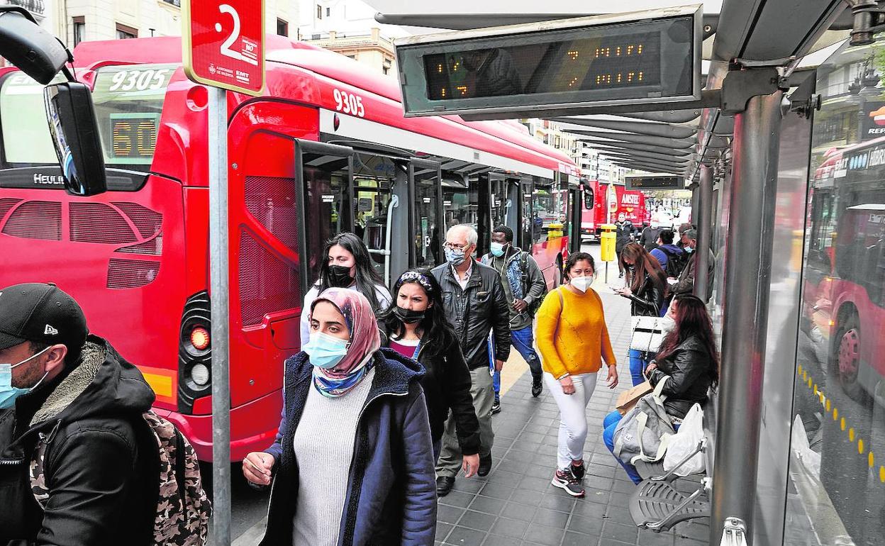 Varias personas en una parada de la EMT.