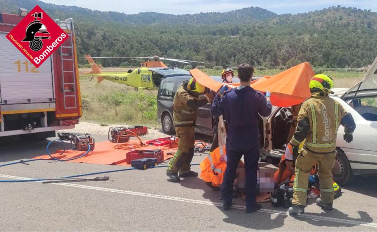 Los bomberos y los sanitarios asisten a uno de los heridos en el accidente de este domingo. 