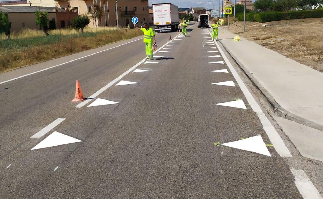 Operarios pintan dientes de dragón en la travesía de Nava de Roa (Burgos) en la N-122, entre los km 293,652 y 294,356. 