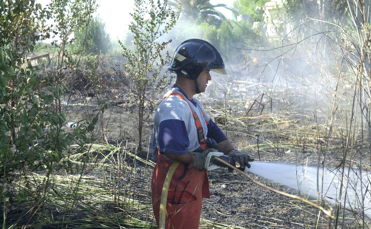 Imagen de archivo de un bombero en la extinción de un incendio en un cañar. 