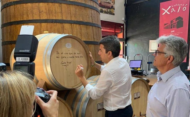 El presidente de la Diputación escribiendo una dedicatoria en un tonel de Bodegas Xaló. 