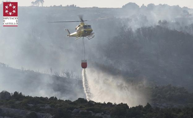 Un helicóptero trabaja en la extinción del fuego en Xert.