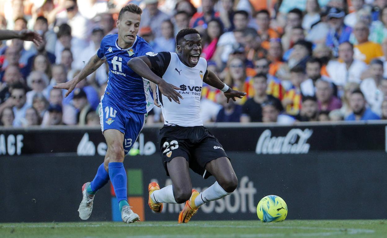 Moriba lucha con Canales durante el partido del Valencia conta el Betis en Mestalla. 