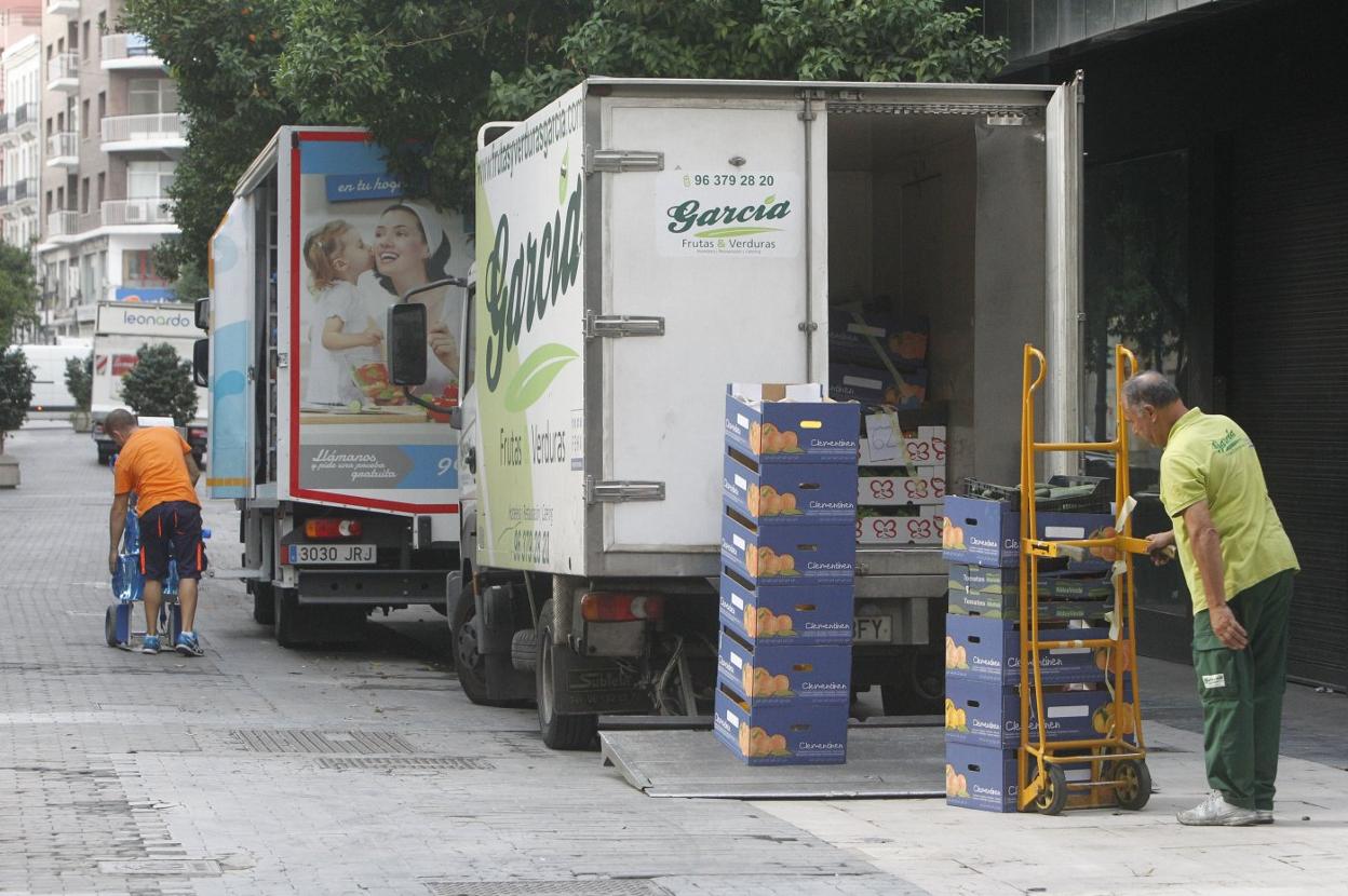 Transportistas descargan mercancía en una calle peatonal de Valencia. manuel molines