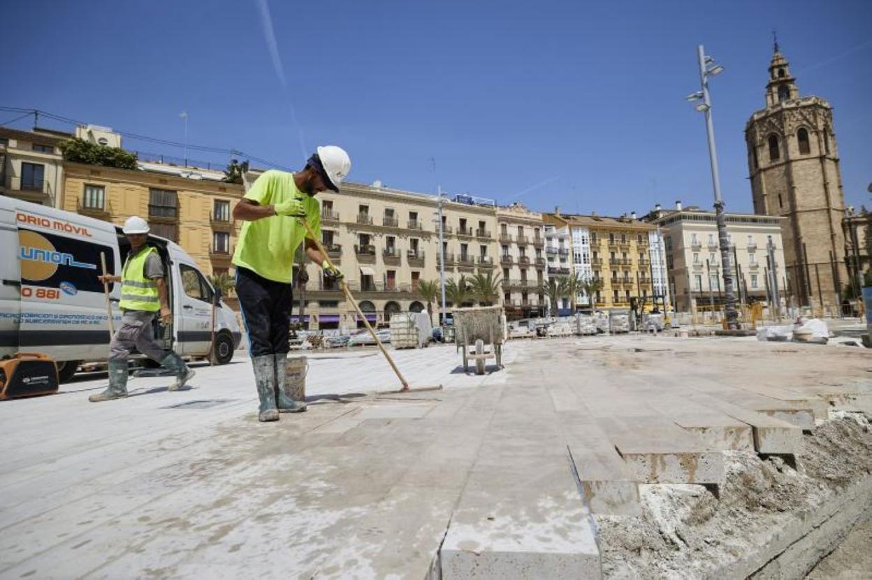 Operarios trabajando en la plaza de la Reina, que debe estar lista a final de mes.