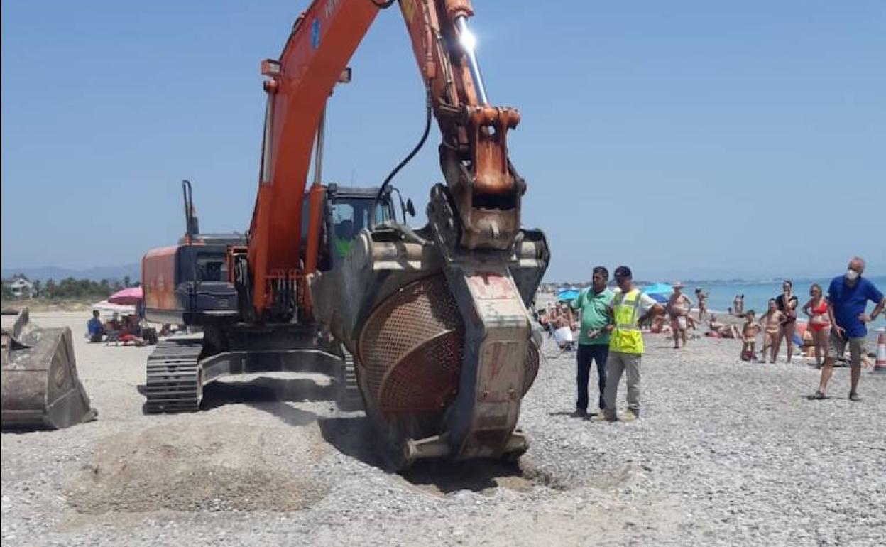 Las labores de retirada, con bañistas en la playa. 